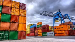 Shipping containers stacked at a container terminal - how freight charges are calculated for USA and Europe shipments