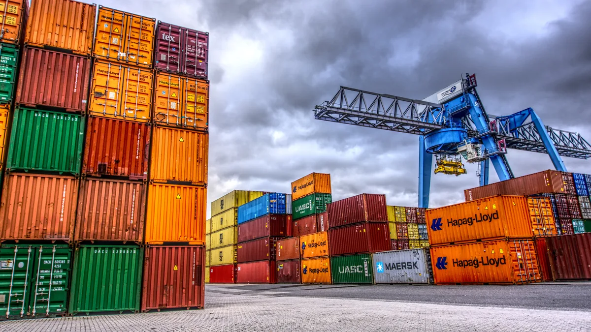 Shipping containers stacked at a container terminal - how freight charges are calculated for USA and Europe shipments